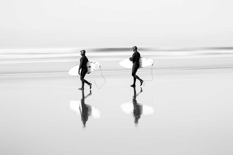 Surfers on beach by Scott Fisher